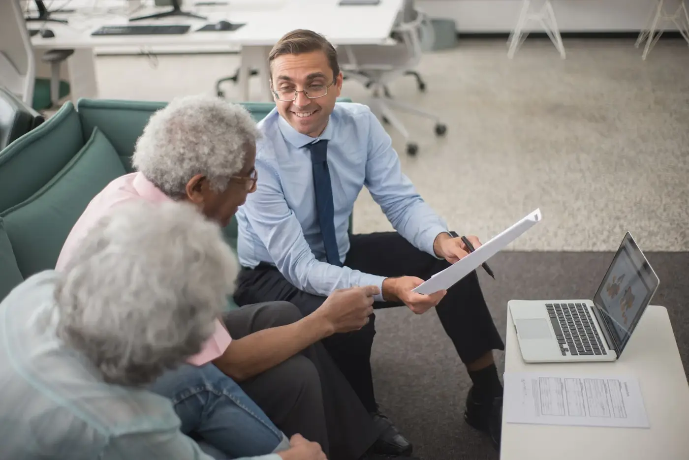 About us: our reviews and how we work 1 An adviser going through a document with an older couple in an office lounge