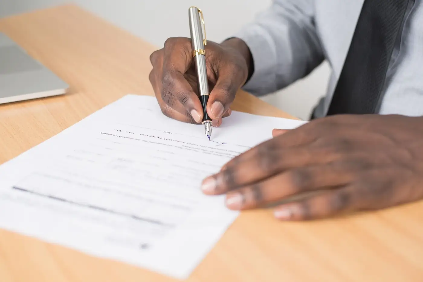 Acknowledgement of Debt in Dubai 3 A man signing a printed statement with a fountain pen at a desk