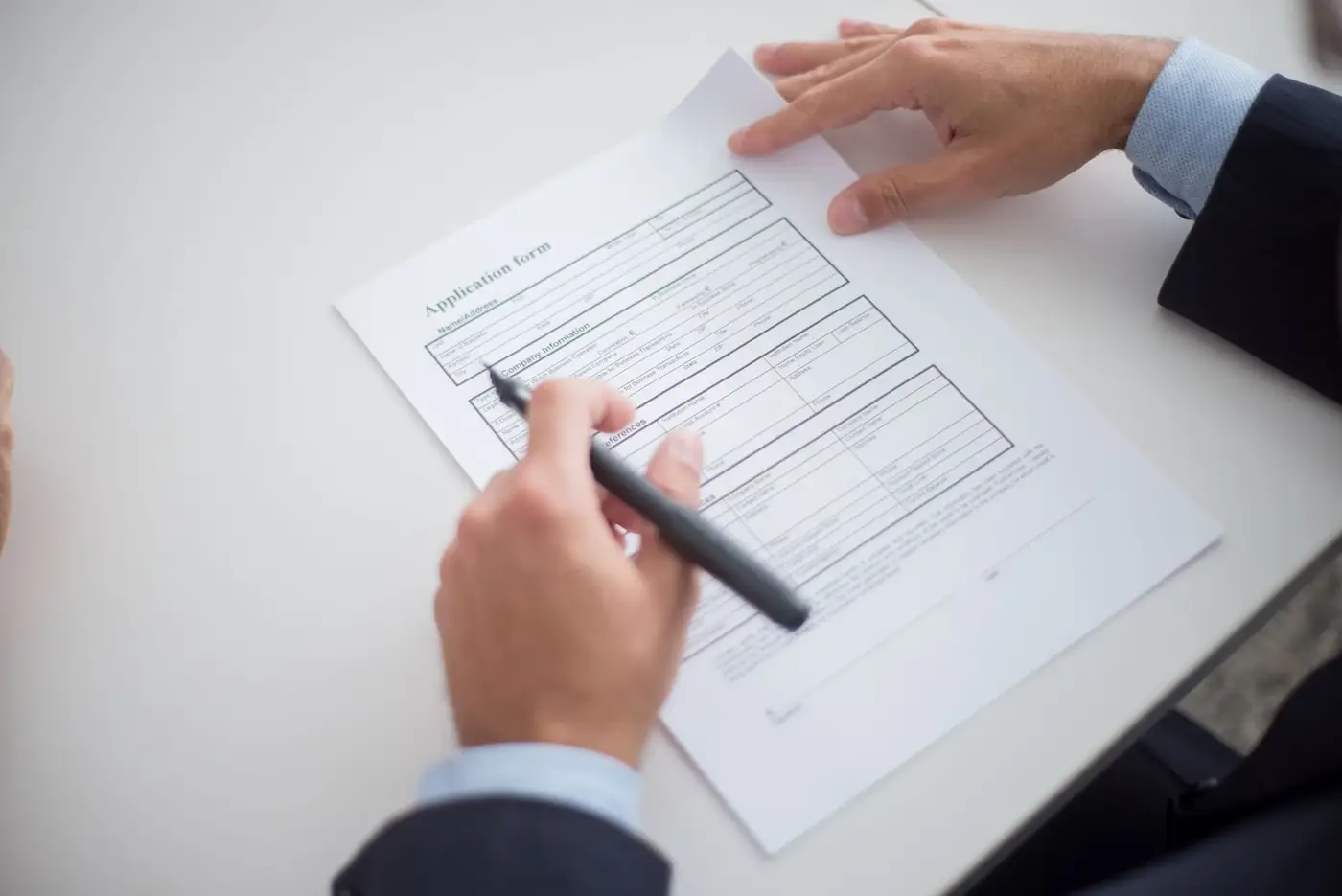 Degree Certificate Attestation for the UAE, Explained 5 A man filling in a printed application form with a pen