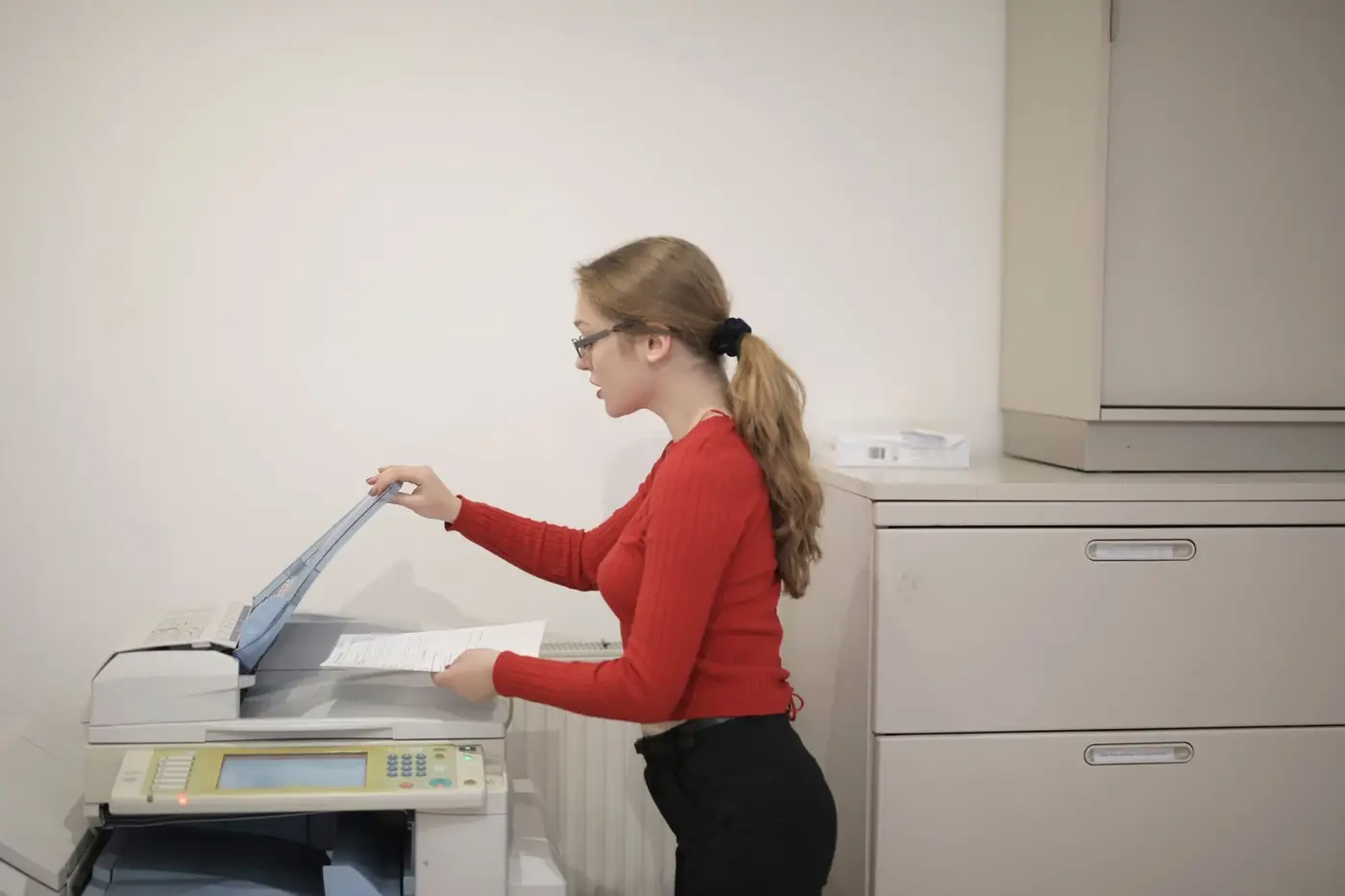 Certified True Copy Attestation in Abu Dhabi 1 A woman placing a document on an office photocopier