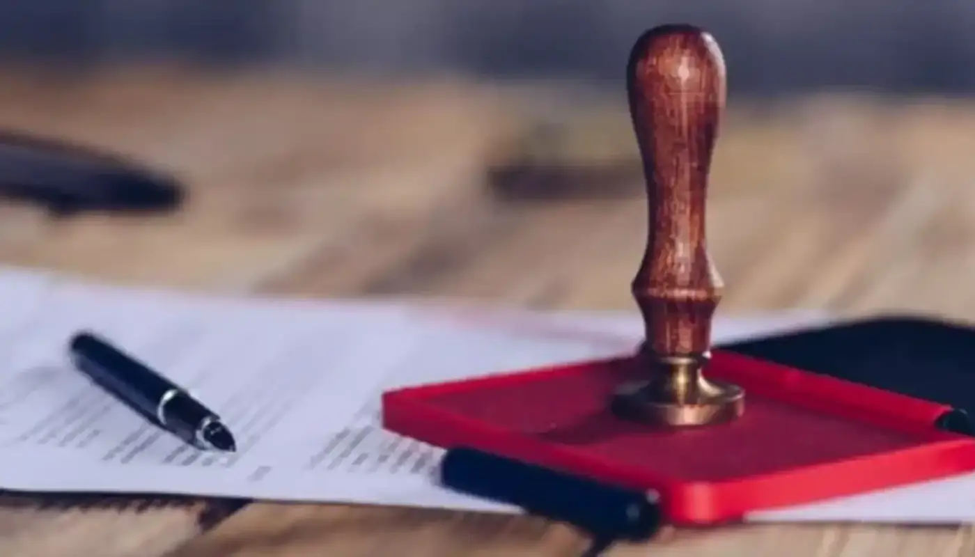 Certified True Copy Attestation in Sharjah 1 A wooden stamp on a red ink pad next to a pen