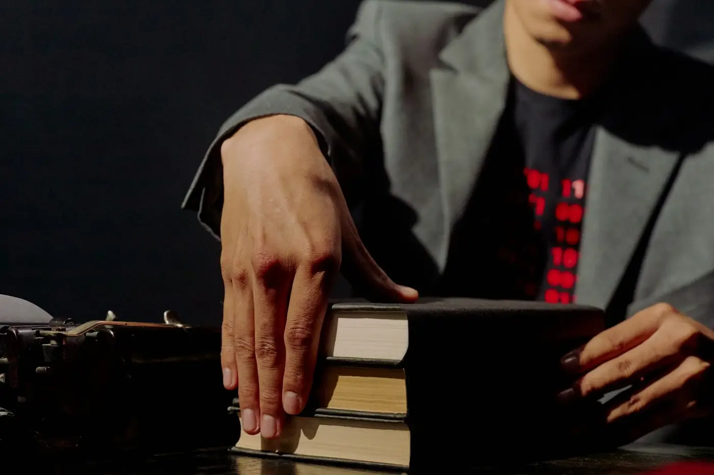 Commissioner of Oaths in Dubai: How to Get a Document Sworn 1 A man in a jacket resting his hand on a stack of books