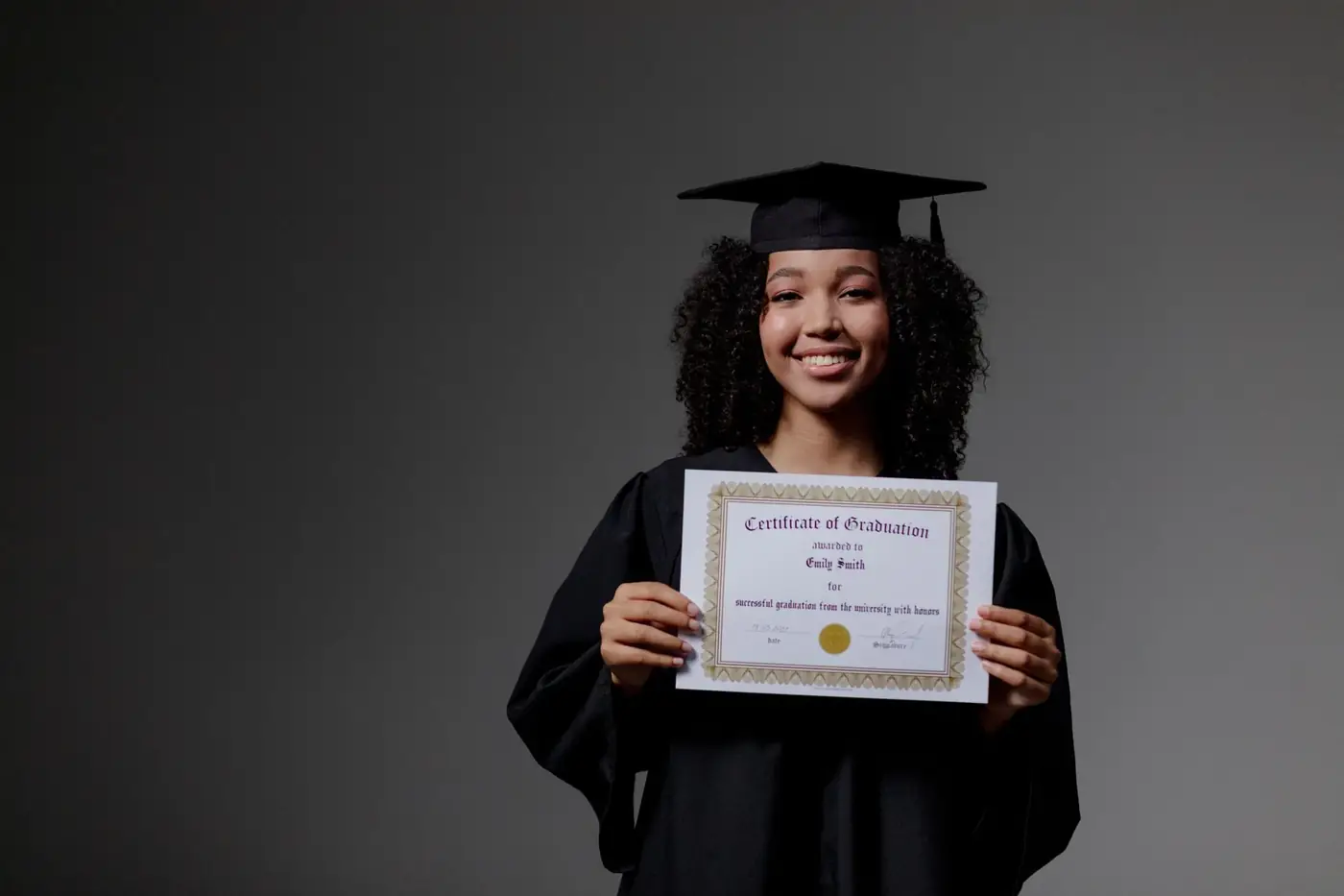 Degree Certificate Attestation for the UAE, Explained 1 A graduate in cap and gown holding up a graduation certificate