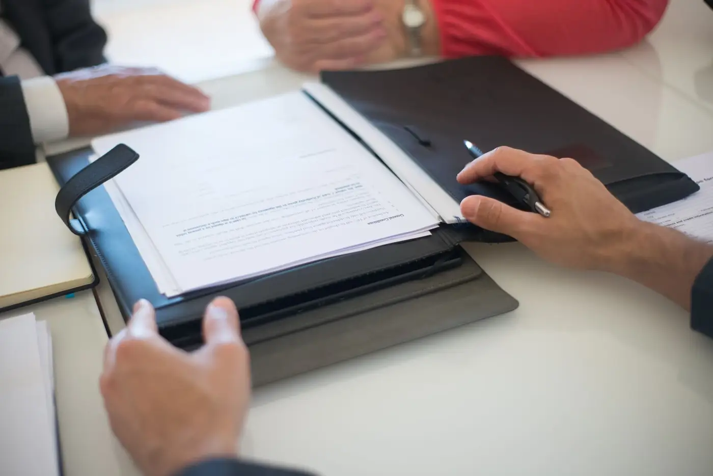 Eviction Notice in Dubai: The 12 Month Notice and How to Serve It 5 Two people reviewing a printed contract in a folder on a meeting table