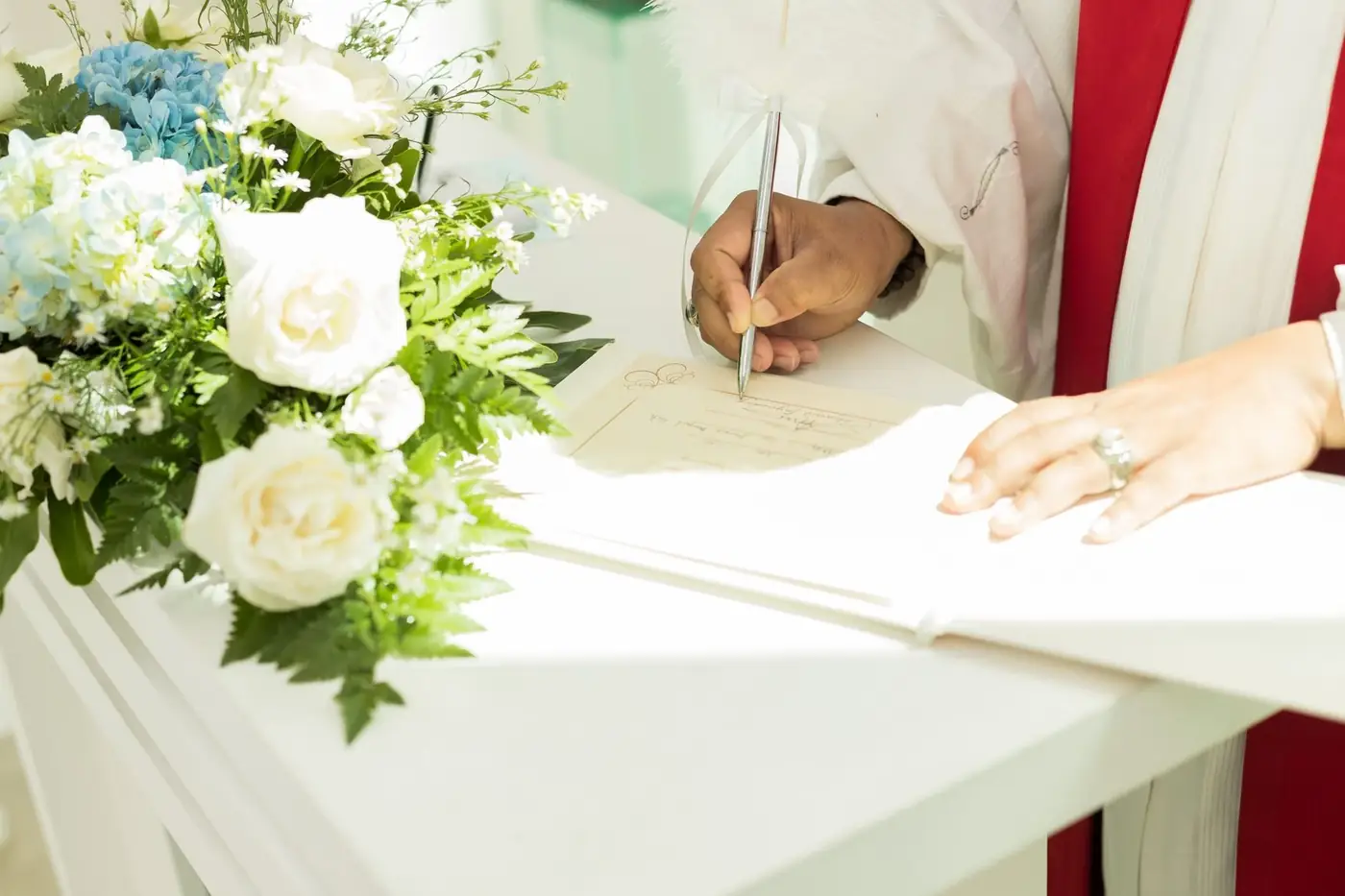 Degree Certificate Attestation for the UAE, Explained 4 A marriage certificate being signed on a white table beside white flowers