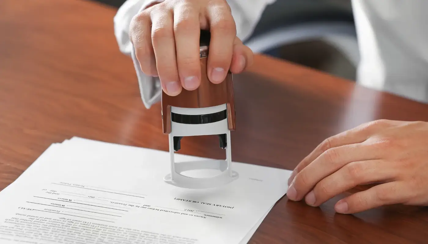 Notary public meaning, and what notarised means for your document 1 A hand pressing a notary stamp onto a document