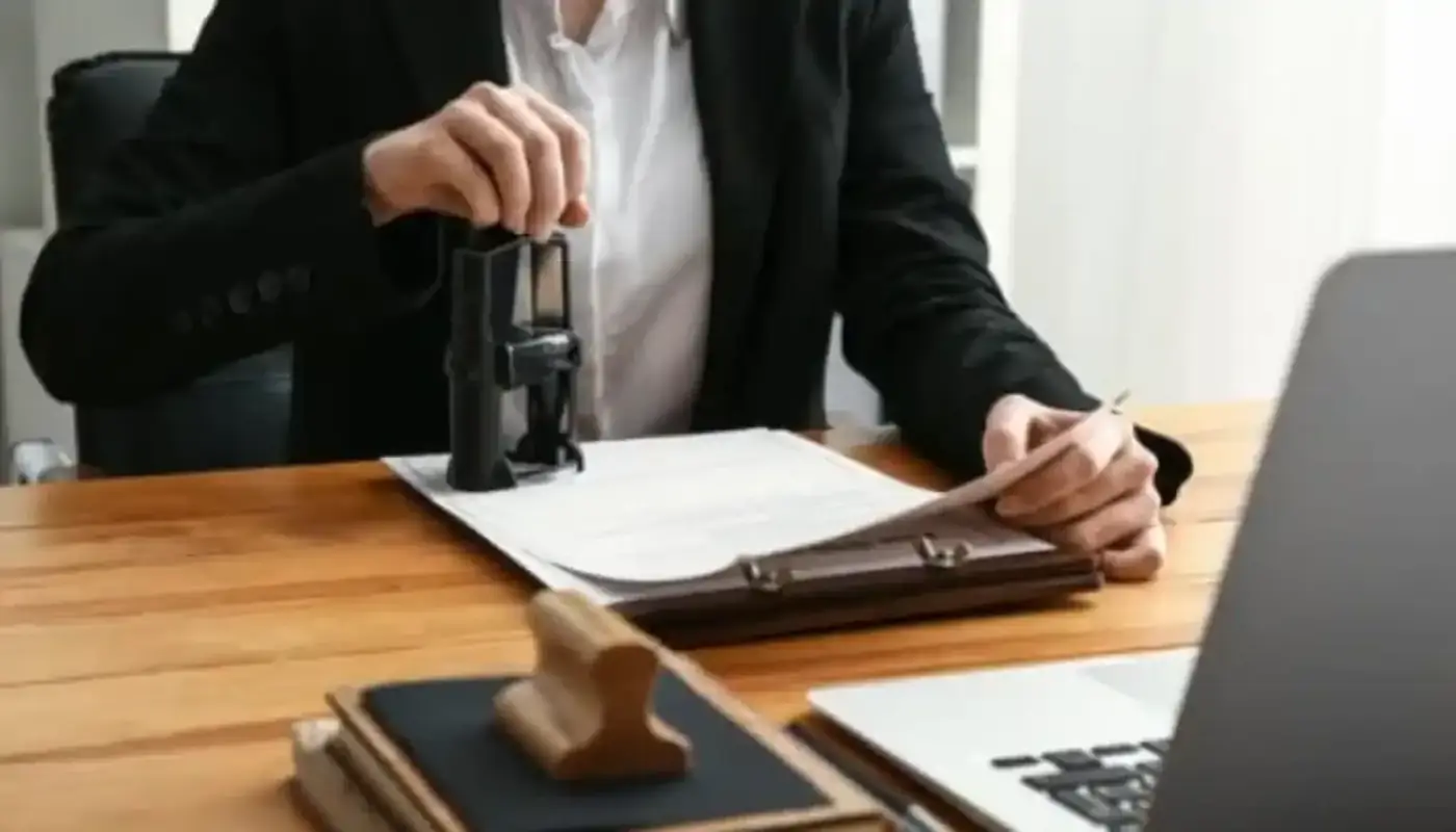 Notary Public in Sharjah 1 A person stamping a document at a desk