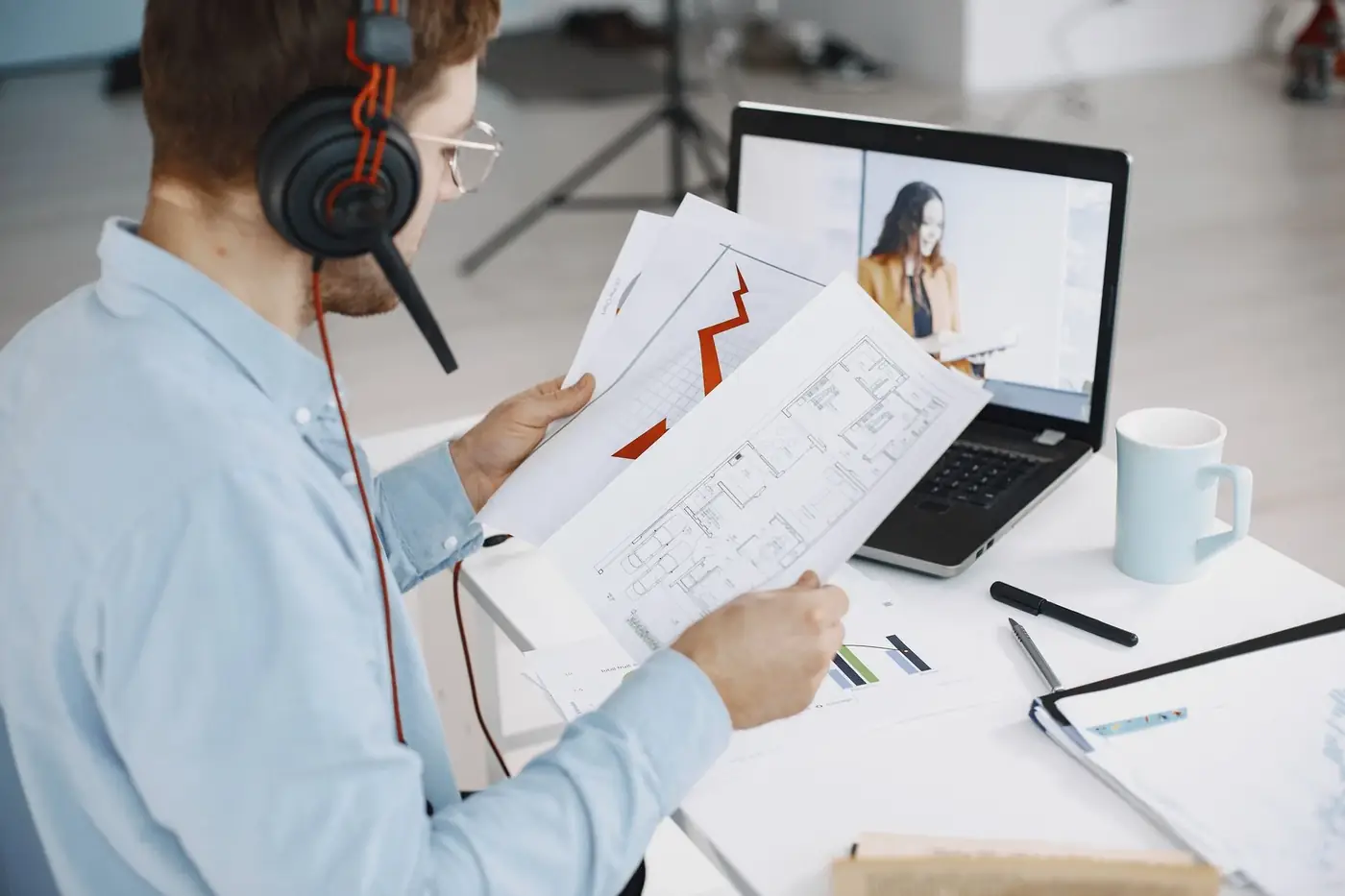 E-notary in Dubai and the UAE, explained step by step 2 A man with a headset holding documents during a video call on his laptop