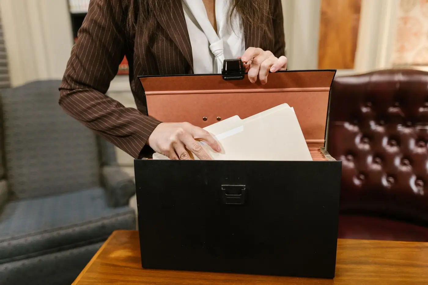Power of Attorney for Dubai Courts and Court Cases 1 A woman in a pinstripe suit taking a folder from a black file box