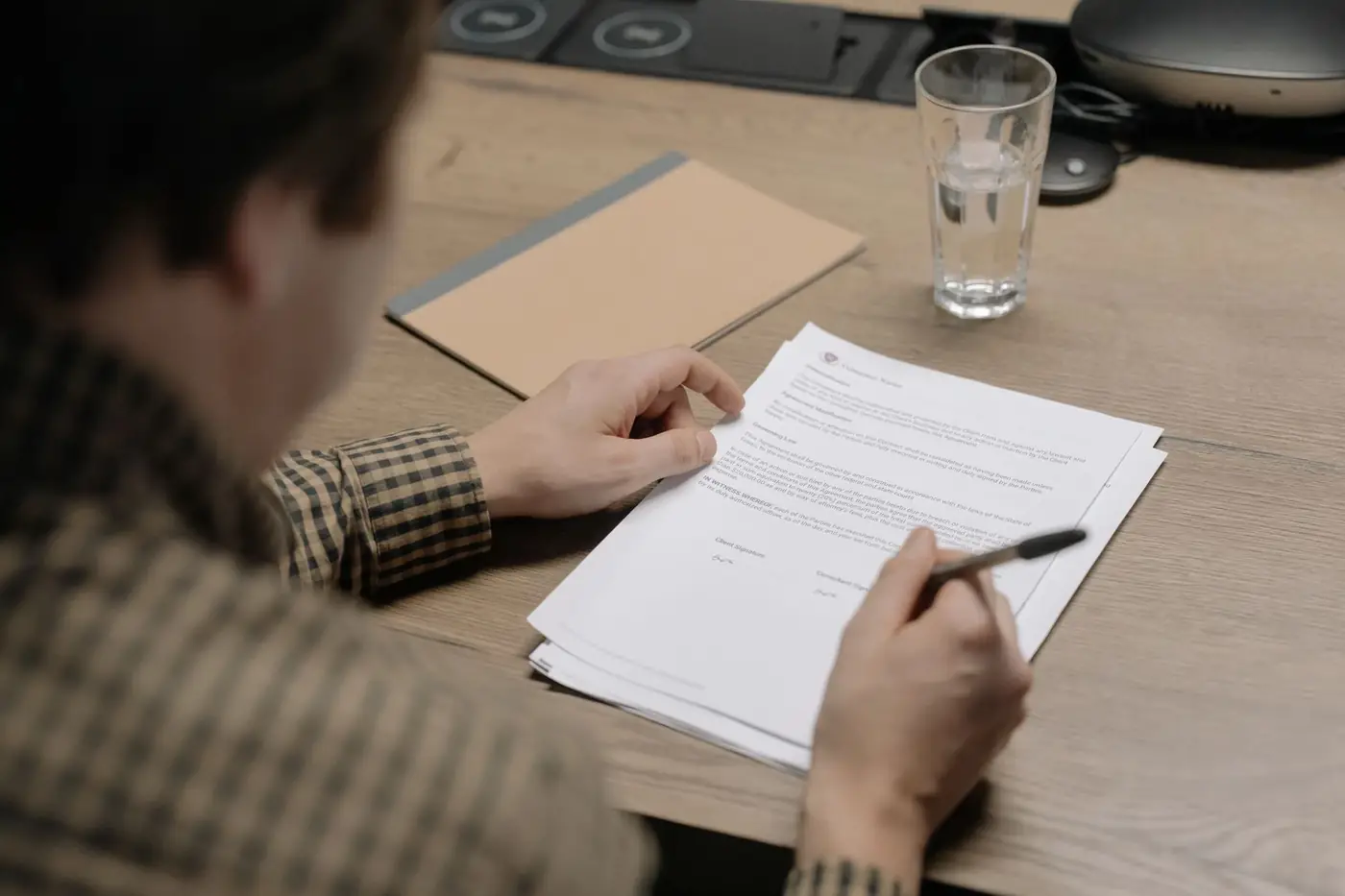 Share Transfer Power of Attorney in Dubai and the UAE 1 A man signing a multi page company agreement at a meeting table