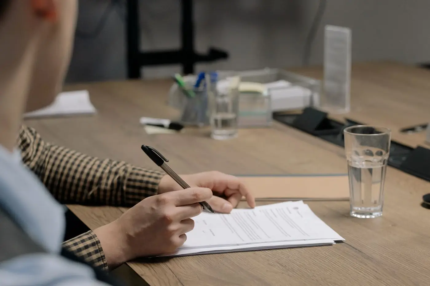 Notary public meaning, and what notarised means for your document 3 A man signing a document at a quiet meeting table