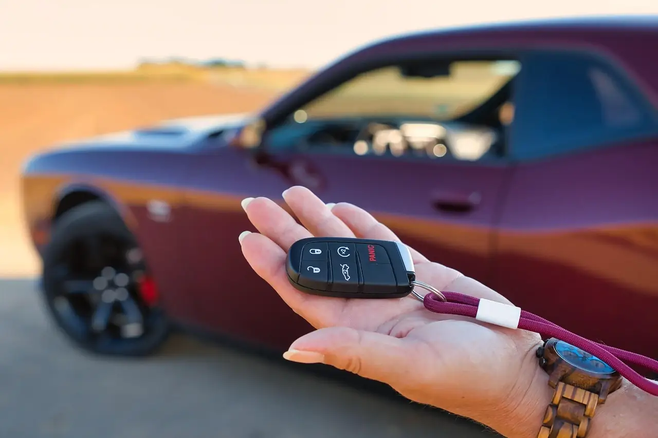 Vehicle Power of Attorney in the UAE 1 A hand holding a car key fob in front of a parked car